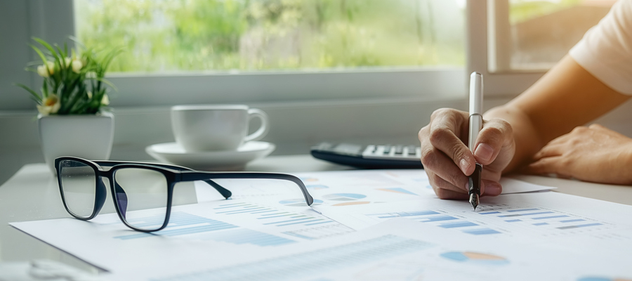 A businessman reviewing a printout of an AI business plan generator bar charts on his table.
