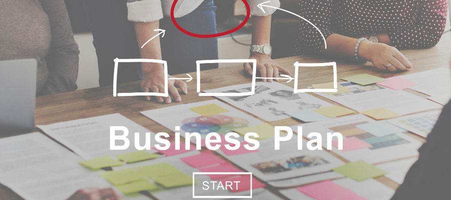 A team with a business plan overlay looking at business planning outputs on a table.