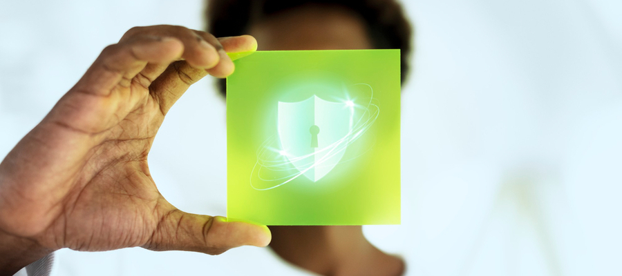 A man holding a security protection hologram that shields his face.