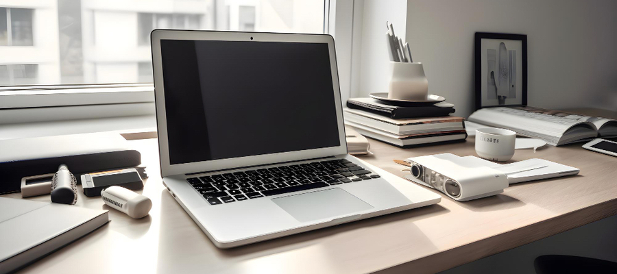 A desk with a laptop, books and  technology education materials.