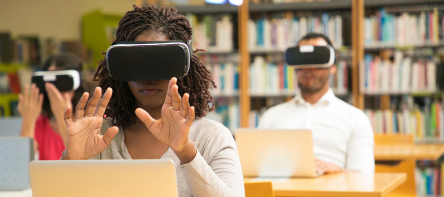 A female college student immersing herself on augmented reality in education while seated in a library.