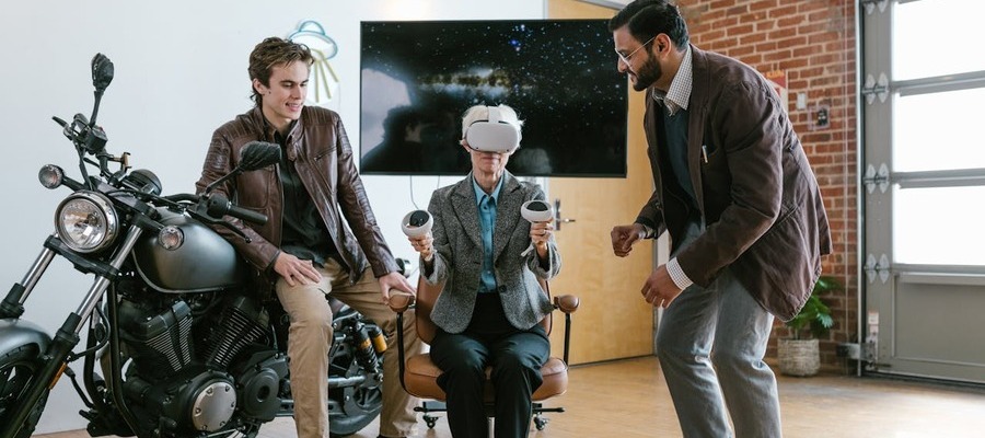 Two young men sowing and older woman how to use AR AI technologies.